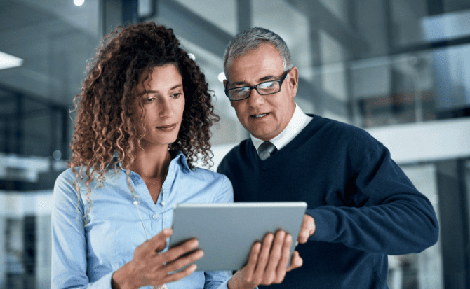 A clear view of the man and woman looking at the tablet.