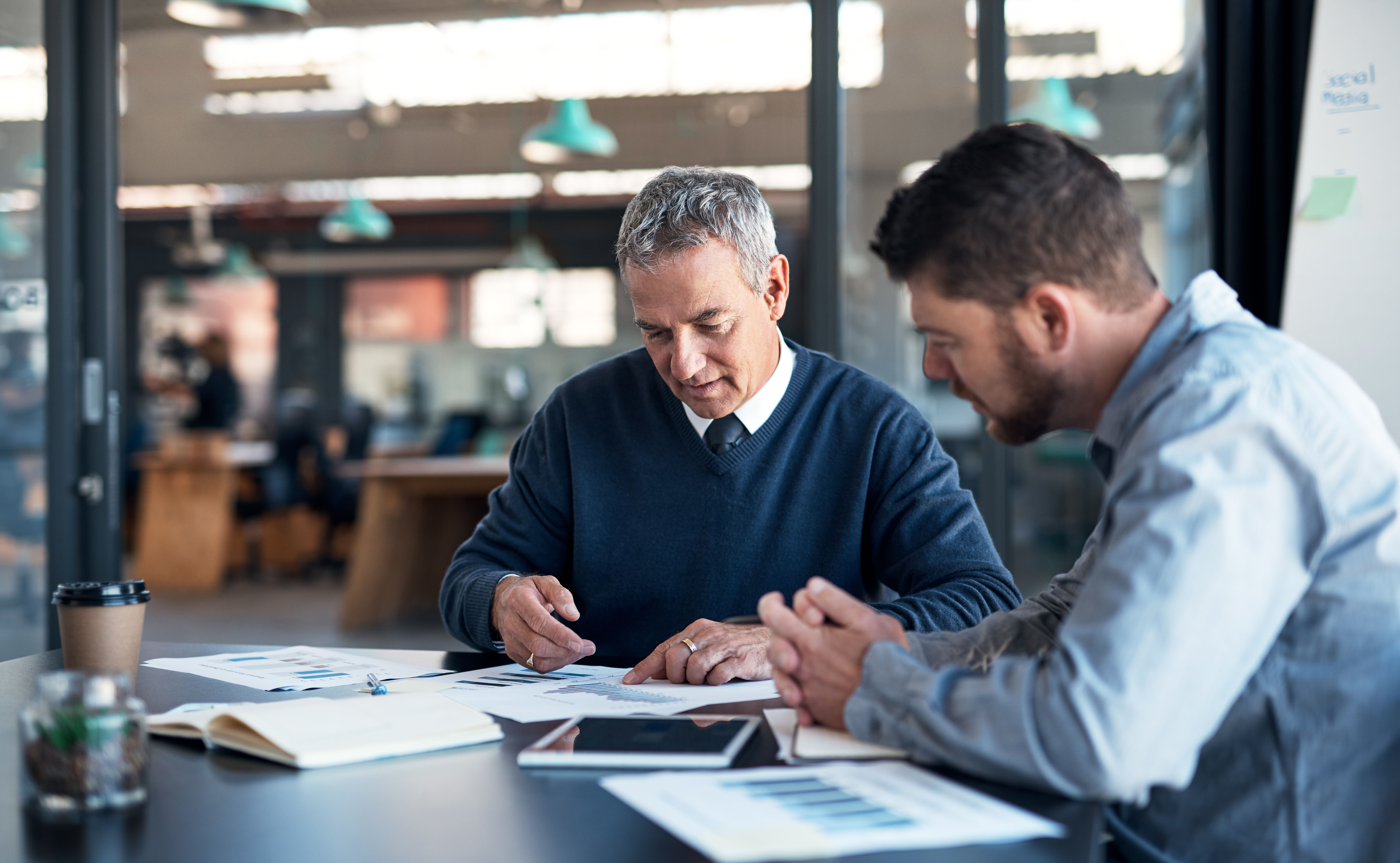 Zwei Fachleute, die CSRD-Softwaretools in einer Büroumgebung überprüfen. 