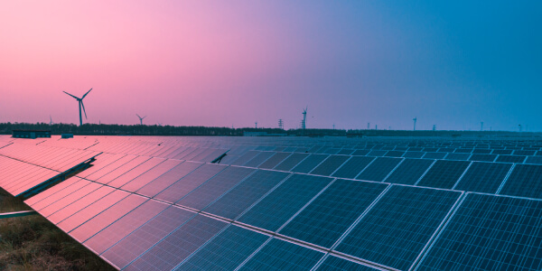 Wind turbine and solar panels representing clean energy initiatives—illustrating the environmental aspect of "What is ESG reporting."